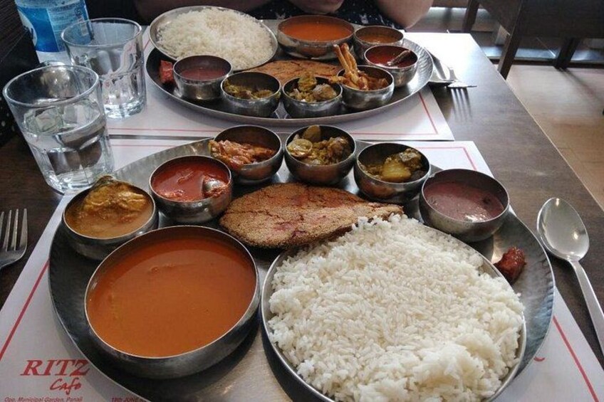 Un plato de comida con arroz, sopa y diferentes curris. 5
