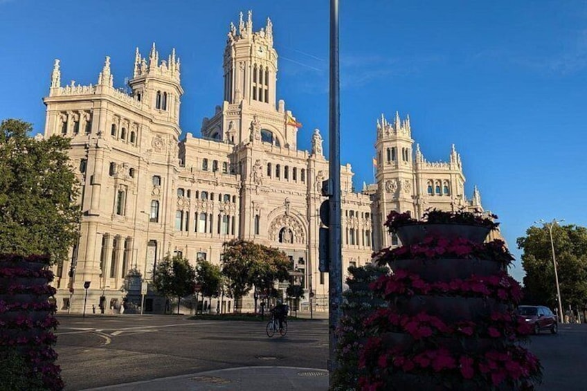 A grand, ornate building with intricate architectural details, a clear blue sky, and a bicycle in the foreground. 5