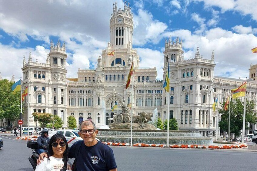 A historic building with ornate architecture, a fountain, and multiple flags. 3