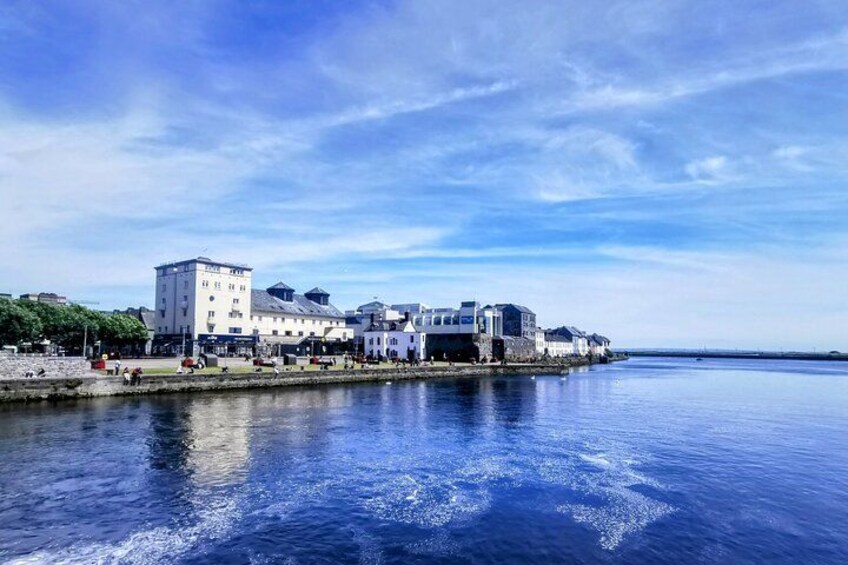 Een waterkant met gebouwen, kalm water en een heldere lucht. 3