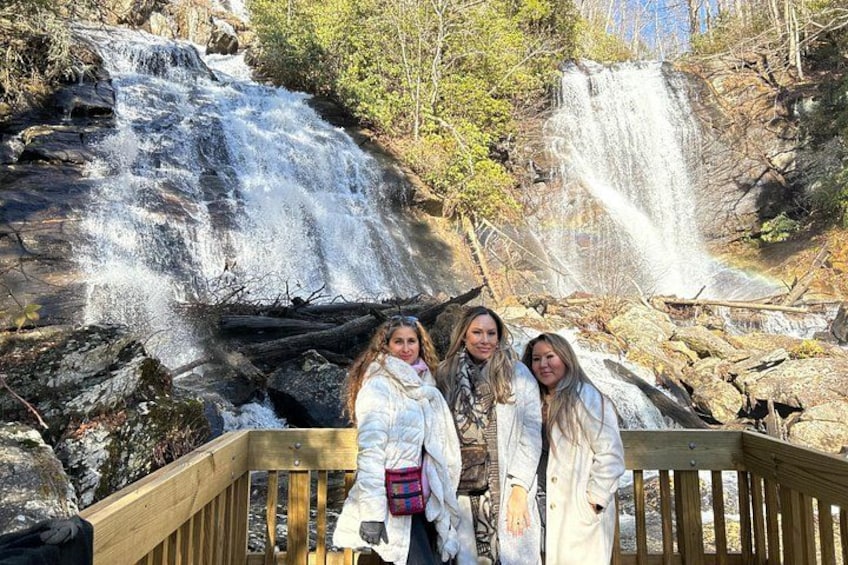 A wooden deck with a waterfall in the background. 1