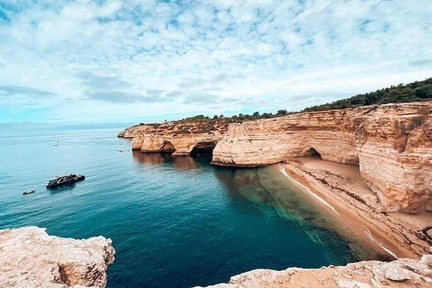 Paesaggio costiero con scogliere, acqua blu cristallina e una barca. 4
