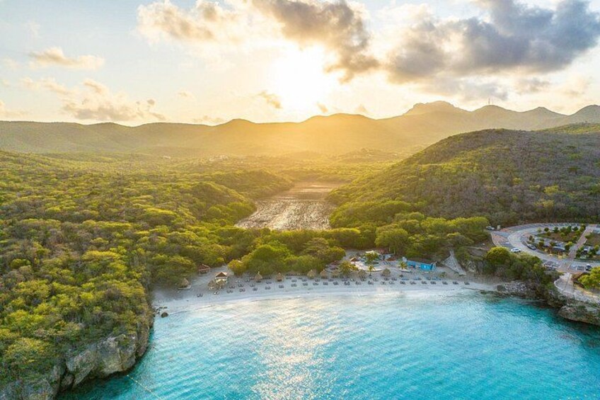 A coastal landscape with a beach, a river, and a mountainous backdrop. 2