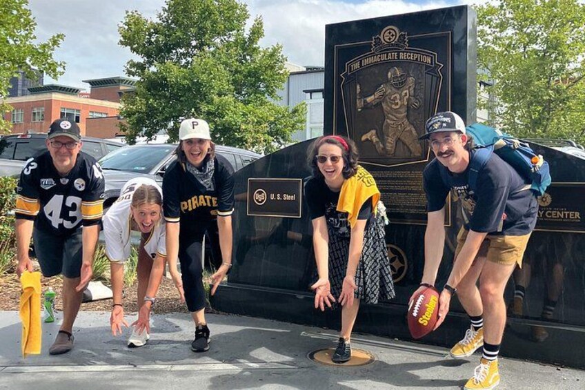 Un grupo de personas posando frente a una placa con un jugador de fútbol. 3