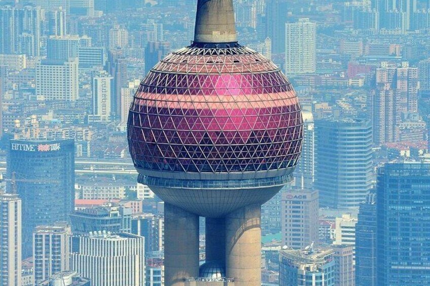 A spherical building with a grid-like pattern, surrounded by a dense urban skyline. 4