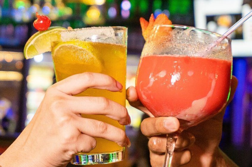 Two cocktails in glasses, one with a lemon slice and cherry, the other with a fruit garnish. 3