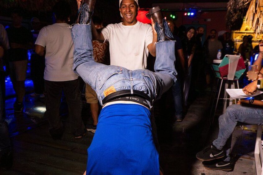 A person performing a handstand in a crowded indoor setting. 3