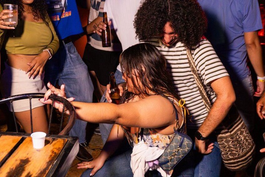 A group of people at a bar with a woman holding a drink. 3
