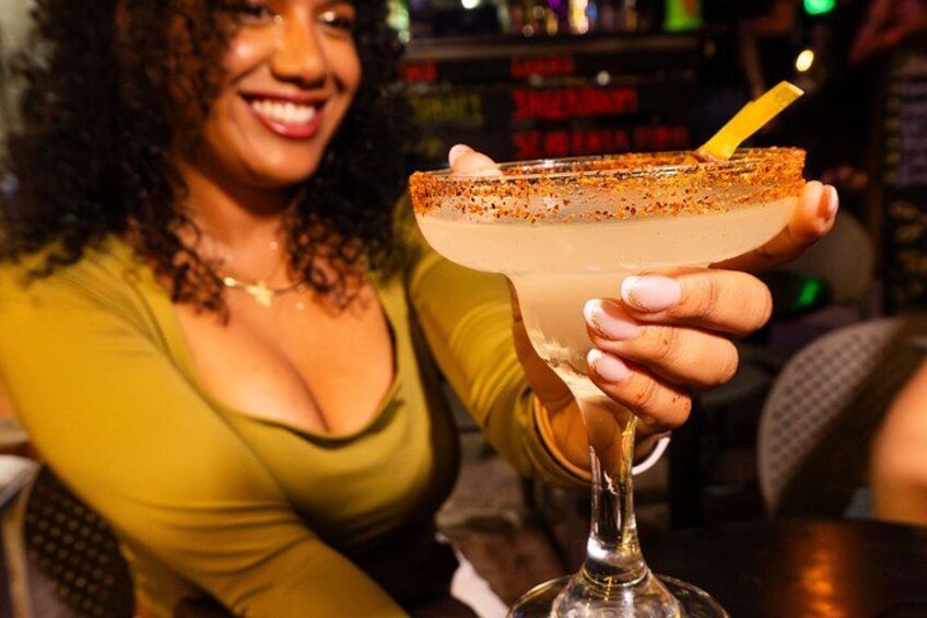 A person holding a margarita with a salted rim and a straw. 2