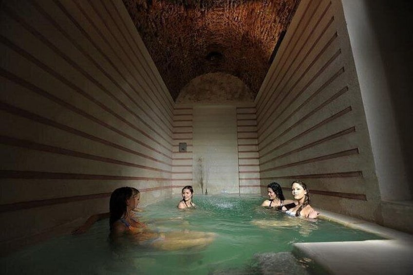 A spa with a stone interior and a central hot tub. 5