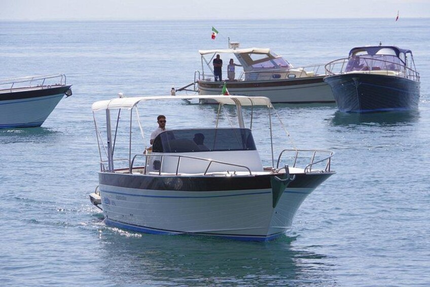 A calm sea with several boats anchored. 2