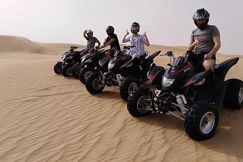 Four quad bikes on a sandy terrain. 2