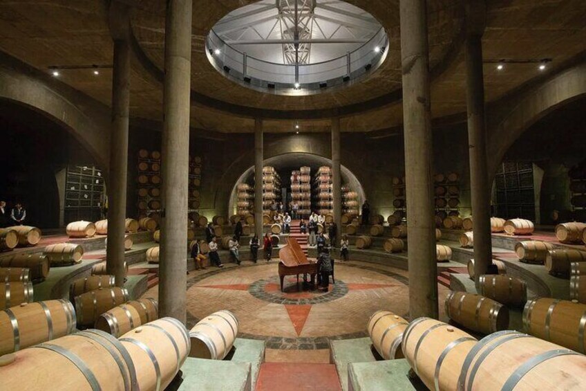 A wine cellar with barrels and a central table. 4