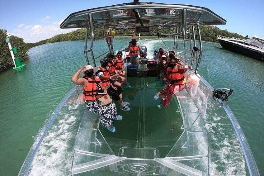 A boat with passengers wearing life jackets, surrounded by calm water and greenery. 2