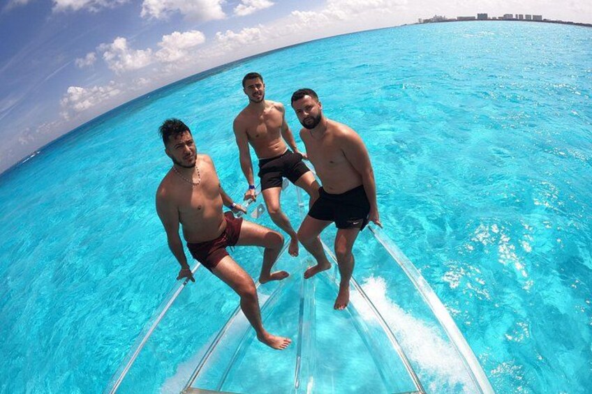 Three people in a clear blue pool with a boat. 1