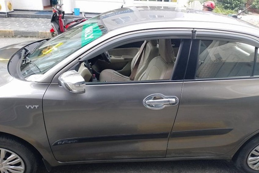 A VVT model car parked on a street with a visible side mirror and door handle. 4