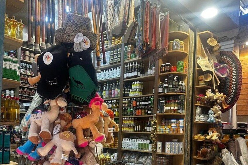 A store with shelves stocked with various items, including bottles and stuffed toys. 2