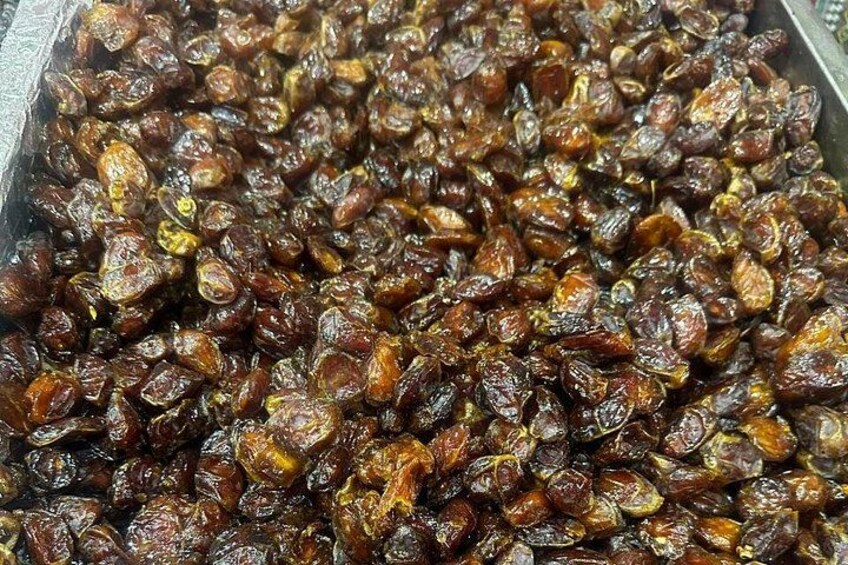 A large quantity of dried fruits, possibly raisins, in a container. 4