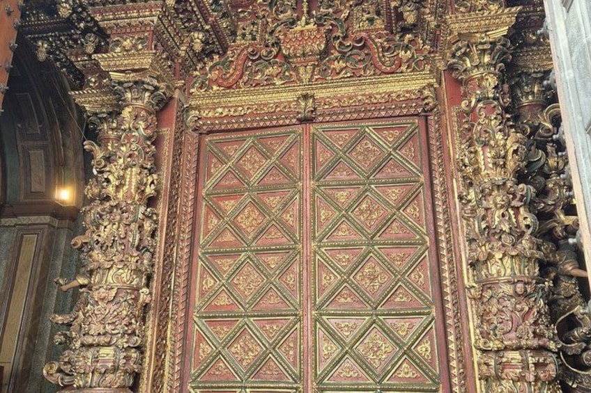 An ornate temple entrance with intricate carvings and a large, detailed door. 1