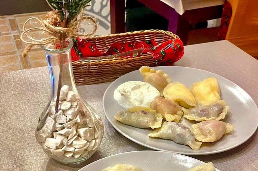 A plate of dumplings, a glass jar with white cubes, and a red basket with a green plant. 3