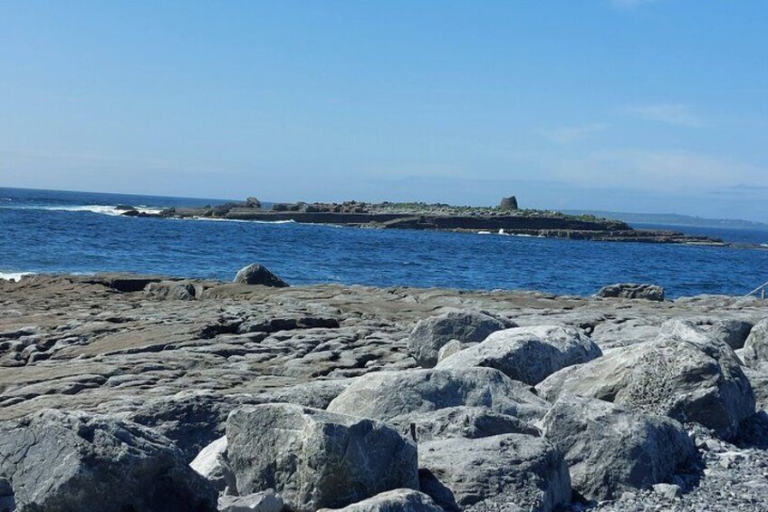 Una costa rocciosa con grandi massi e una vista sullo sfumato mare. 2