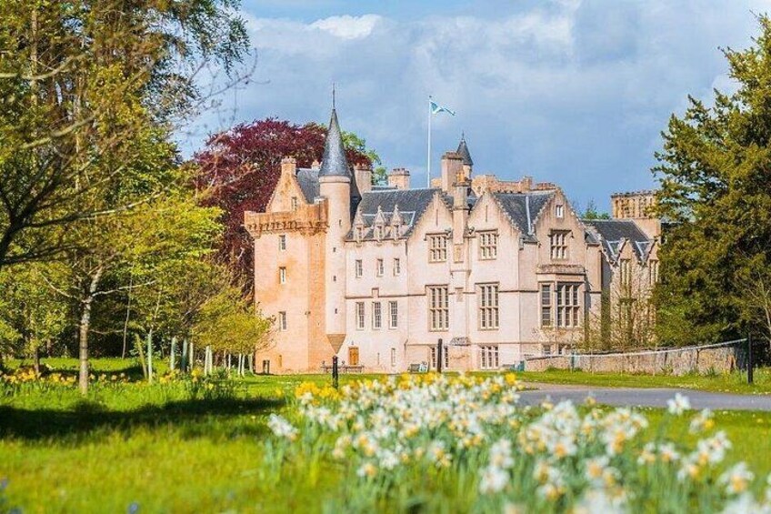 Un grand bâtiment ressemblant à un château, doté de nombreuses tours et arborant un drapeau. 1