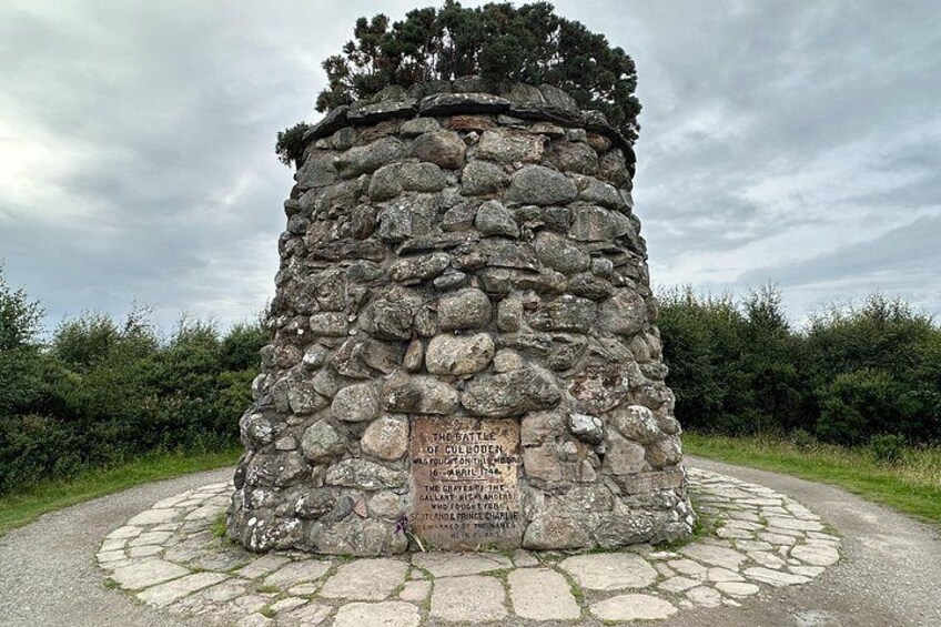 Un monument de pierre orné d’inscriptions, entouré d’un sentier circulaire également en pierre. 4