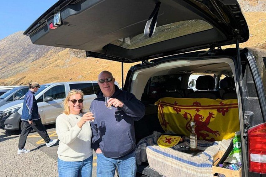 A van with a flag, a bottle, and a blanket in the back. 3