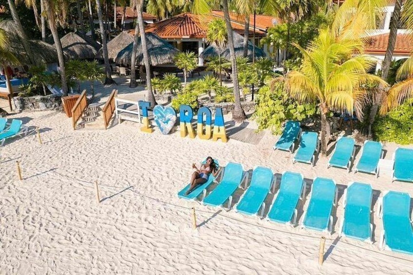 Una playa con tumbonas y un cartel que dice 'TORO'. 2