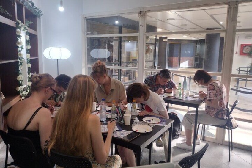A group of people sitting around a table in a cafe, engaged in conversation and eating. 5