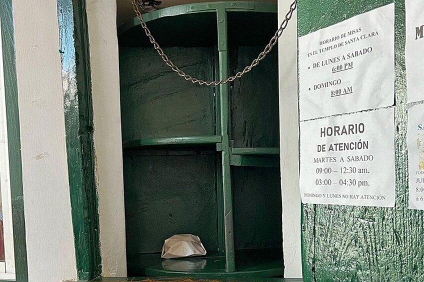A chain hanging from a window, a white paper with a schedule, and a green wall. 3