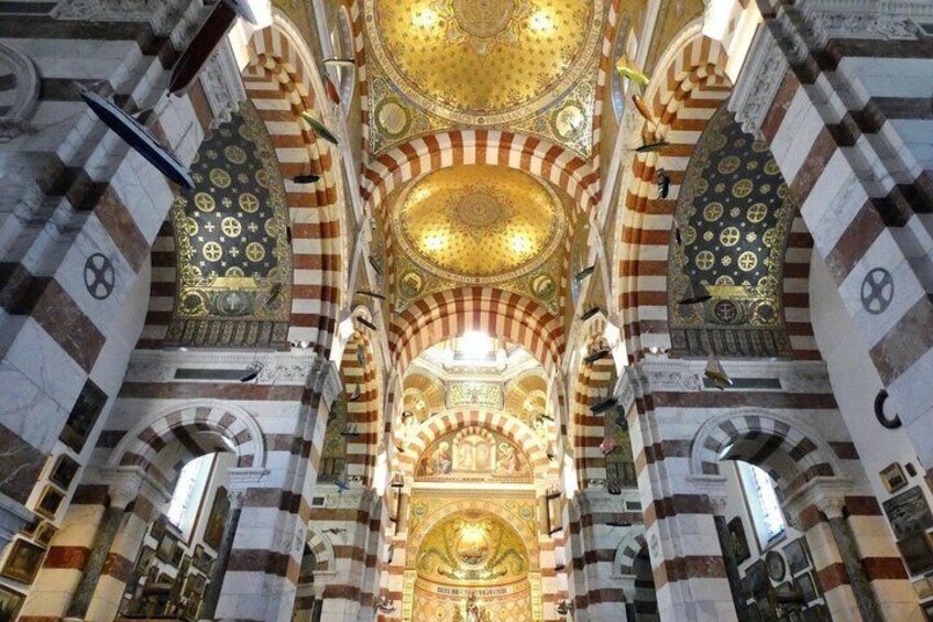 A grand interior with striped arches, a large golden dome, and intricate patterns. 3