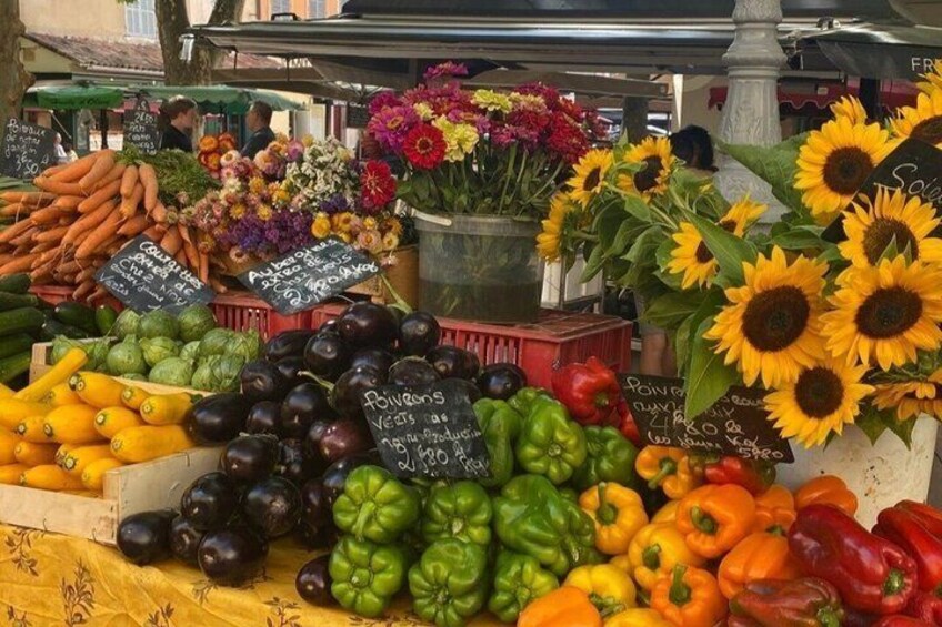 A market stall with various vegetables and flowers. 5
