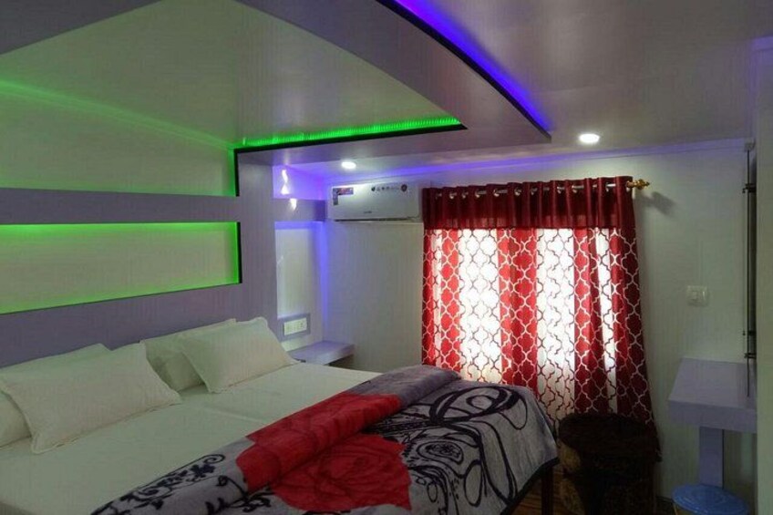 A bedroom with a bed, red curtains, and green ambient lighting. 4