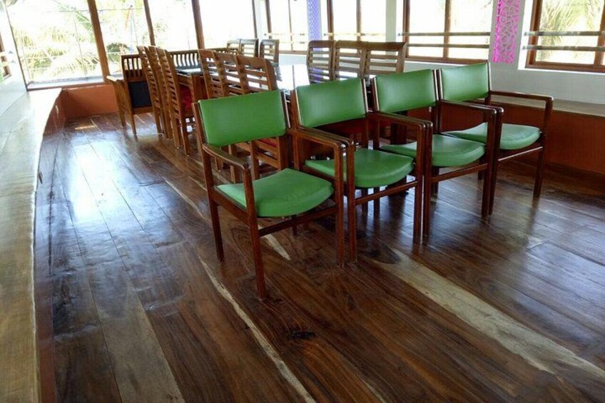 A room with wooden flooring and green chairs. 3
