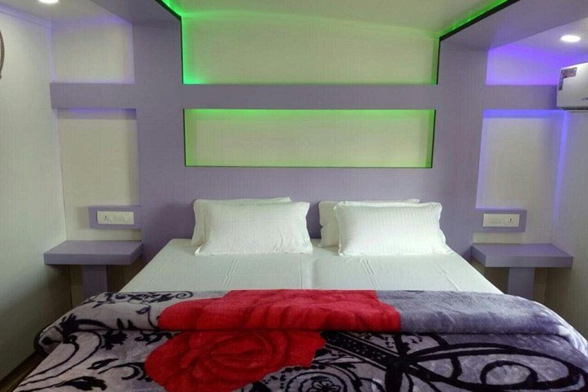 A modern bedroom with a bed, nightstands, and green ambient lighting. 5