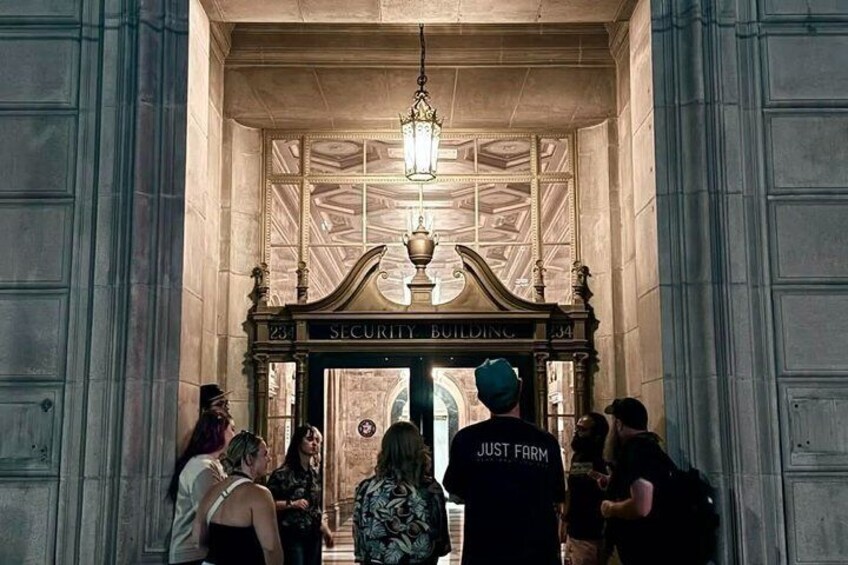 A group of people entering a building with a sign that reads 'SECURITY BUILDING.' 4