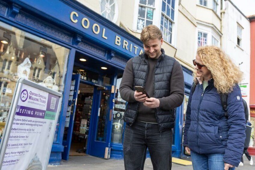 A man and a woman standing outside a blue storefront with a sign that reads 'COOL BRITAIN.' 2
