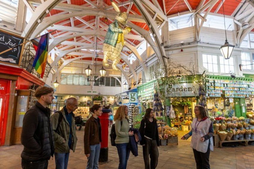 An indoor market with a high ceiling, various stalls, and a central decorative structure. 3