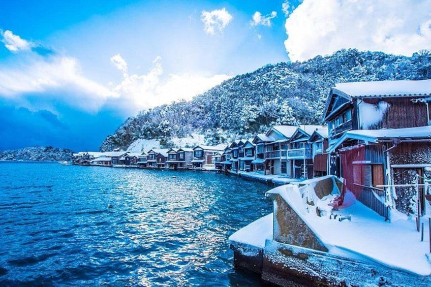 A waterfront village with snow-covered buildings and a clear blue sky. 3