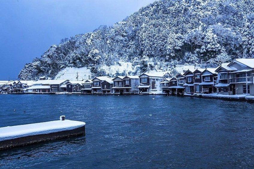 A waterfront with snow-covered buildings and a dock. 4