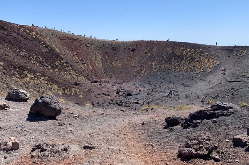 A volcanic landscape with scattered rocks and a steep slope. 5