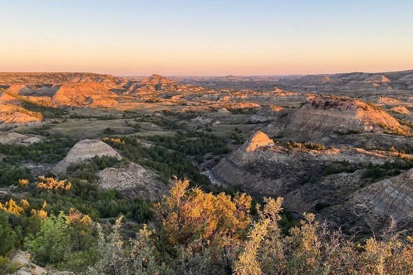 A vast landscape with rolling hills and a mix of green vegetation and rocky outcrops. 2