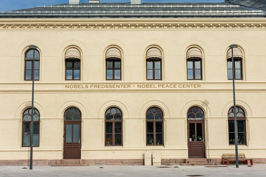 Nobels fredscentrums byggnad med välvda fönster och en skylt med texten ”Nobel Peace Center”. 2