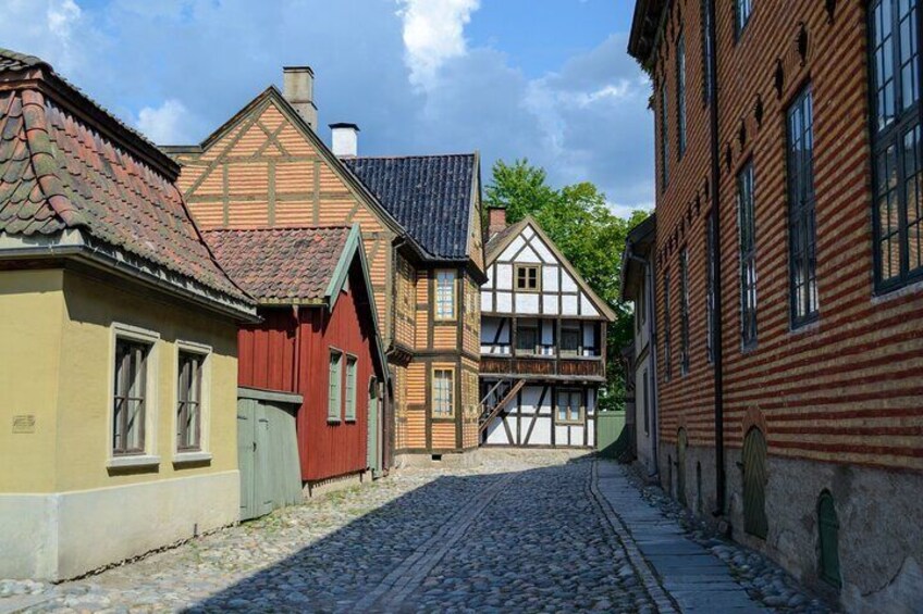 Una calle adoquinada flanqueada por casas tradicionales con entramado de madera. 1