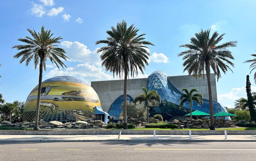 A futuristic building with a large spherical structure and a pyramid-like glass facade. 2