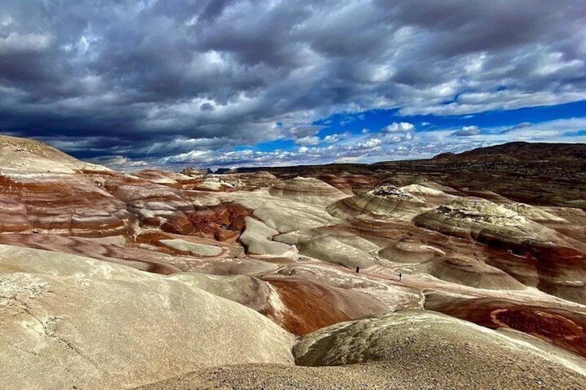 A landscape with layered rock formations and a cloudy sky. 2