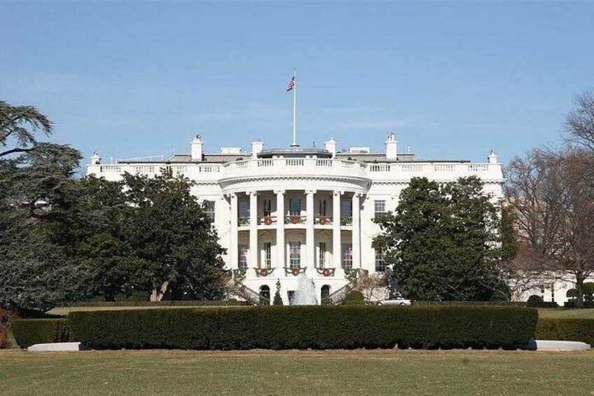 La Casa Blanca con una bandera, rodeada de setos y árboles bien cuidados. 5