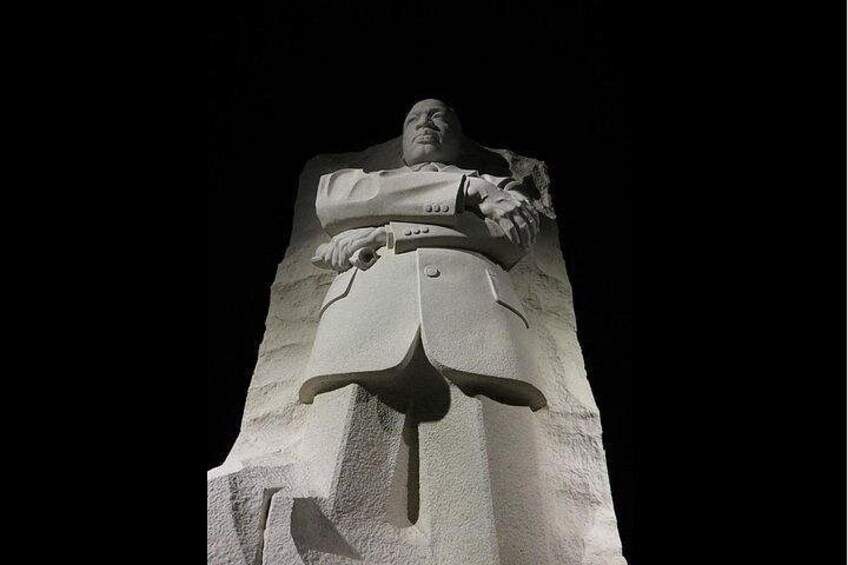 Una estatua imponente de un hombre trajeado con los brazos cruzados, sobre un pedestal. 4