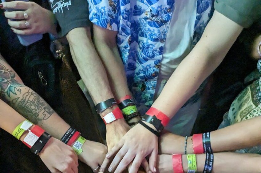 Un groupe de personnes, les mains jointes, portant des bracelets au poignet. 3